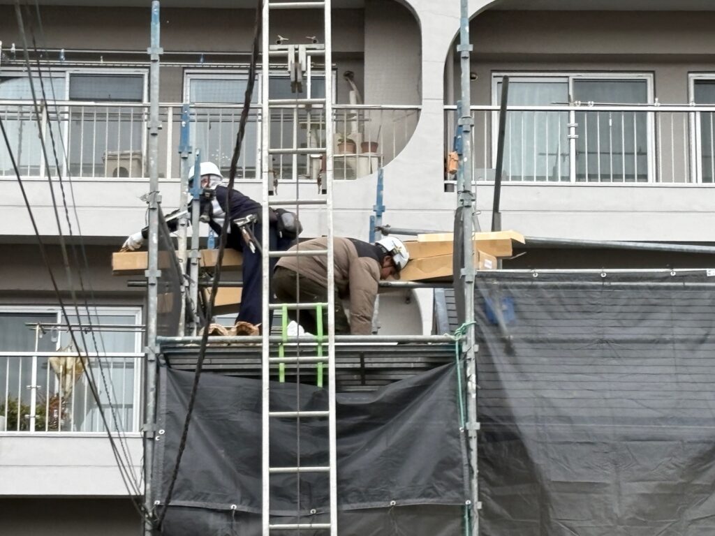 屋根材を搬入している職人の様子