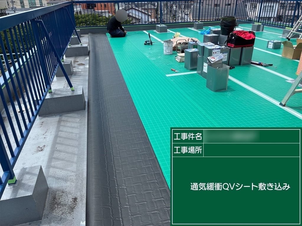 屋上の下地に緑色の通気緩衝シートを敷く作業