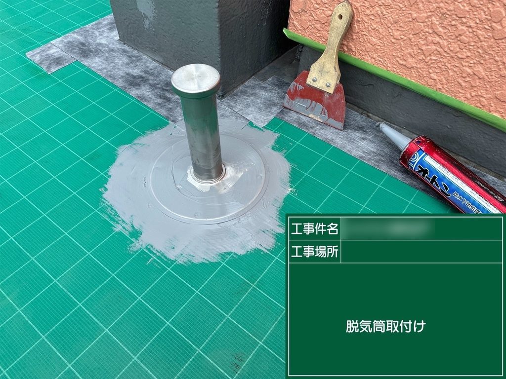 屋上の防水面に脱気筒を取り付ける様子