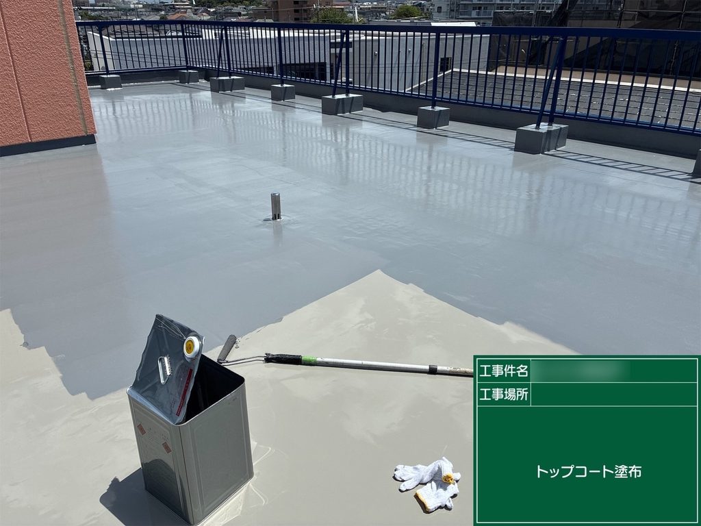 屋上の防水層にトップコートを塗布する作業