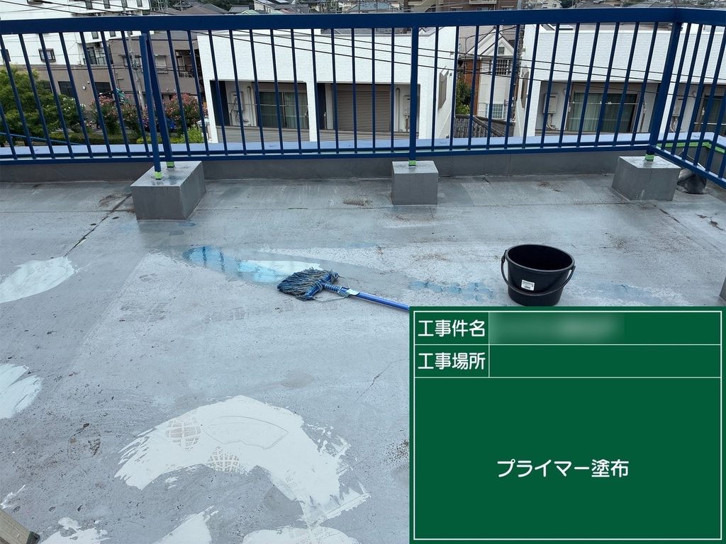 屋上の防水面に下塗り材を塗布する作業