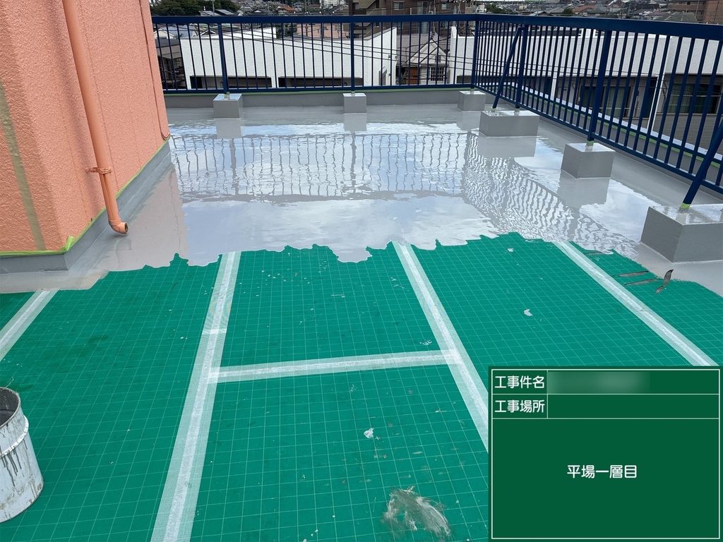 屋上の床面にウレタン防水材を塗布する作業